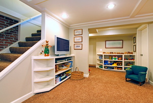 A finished basement with orange carpet and white walls.