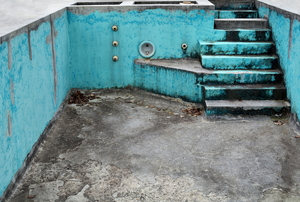 An empty, corroded concrete pool.