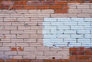 brick wall with red, white, and pink paint