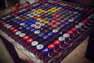 A close-up image of an end table covered in bottle caps. 
