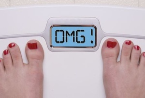 A woman standing on digital weight scale.