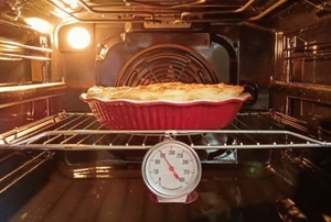 pie in oven with thermometer and light