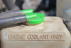 "Engine coolant only" printed on the side of a plastic coolant reservoir.