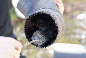 A man cleans a stove pipe.