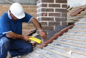 A man installs kickout flashing.