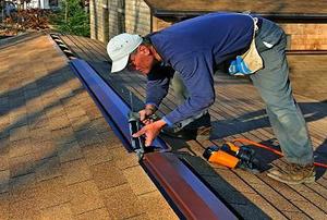 A man caulking a ridge vent.