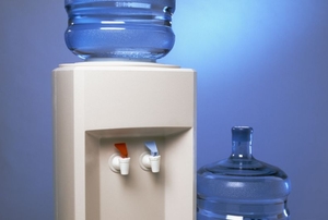 A water cooler with an extra jug beside it.
