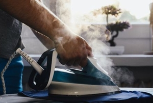 hand ironing fabric with steaming iron