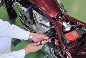 person working on a burgundy-colored motorcycle