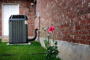 A central air conditioning unit connected to a home from the outside.
