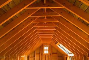 Looking down a long, empty attic toward a single window.
