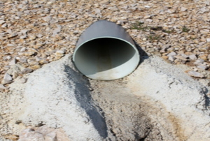 a drain pipe poking out from under dirt