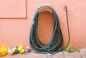 A garden hose on the side of a house.