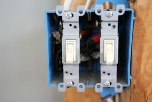 a new double light switch on a wooden post with no cover