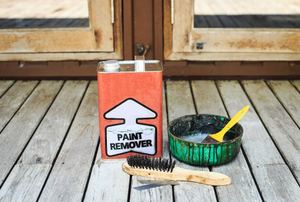 A can of paint remover on a wood deck.