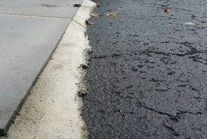 a driveway connects unevenly to a walkway
