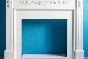 empty fireplace frame in front of blue wall