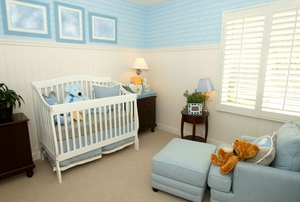 A white baby crib in a blue-themed nursery.