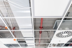drop ceiling with missing tiles revealing HVAC and plumbing systems