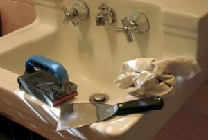 Painting tools resting on a bathroom sink.