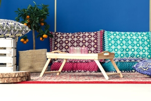 A wood tray in a bohemian decor setting that's part of a design trend.