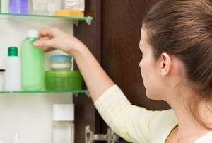 woman opening bathroom cabinet