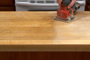 Using a sheet sander on a tabletop.
