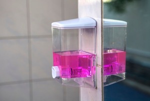 wall-mounted soap dispenser with pink liquid inside