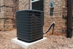 An air conditioning unit outside a brick house.