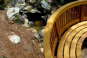A curved wood bench as part of a deck.