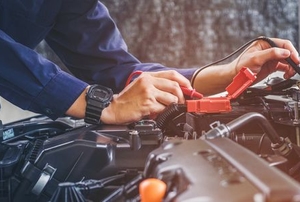 hands checking power in vehicle engine