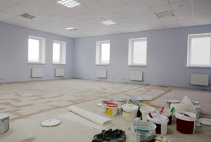 A large room empty except for paint supplies.
