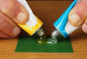 A DIYer blending two substances for a strong metal adhesive.