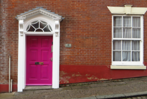 A pink door in a brick building.