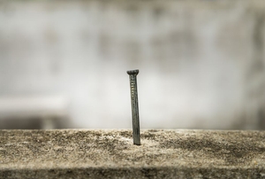 A nail driven into concrete.