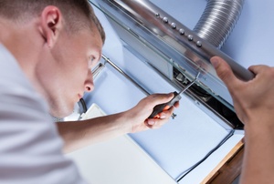A man works on a hood vent system.