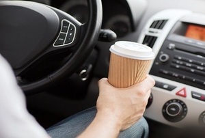 man holding cup in car