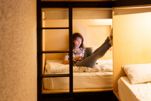girl with laptop in hostel bed