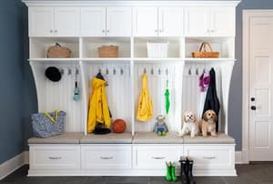 A mudroom with a white storage cabinet and bench. 