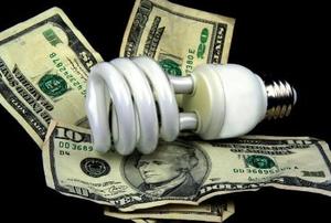 A light bulb on a bed of U.S. currency.