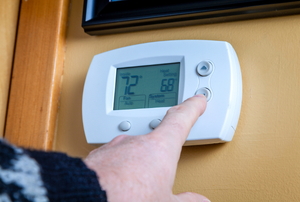 A digital home thermostat on the a wall.