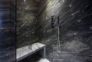 A shower with a frameless glass shower door.