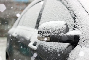 A dark car covered in snow.