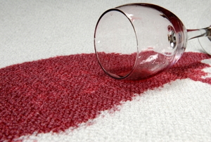 A glass of red wine spilled on carpet.