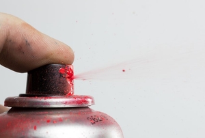 spraying can of red spray paint