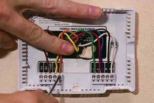 A man works on a thermostat