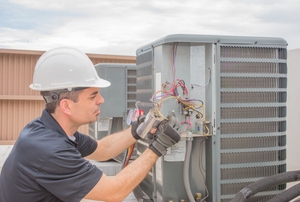 An HVAC technician replacing an AC capacitor.