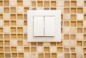 light switch with tiled wall behind it