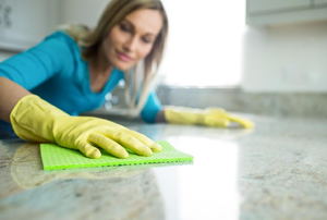 Woman wiping off a granite countertop