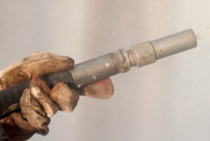 gloved hand holding a sandblaster